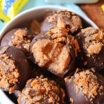 nutter butter butterfinger truffles in a ceramic white bowl with a candy bar wrapper in the background
