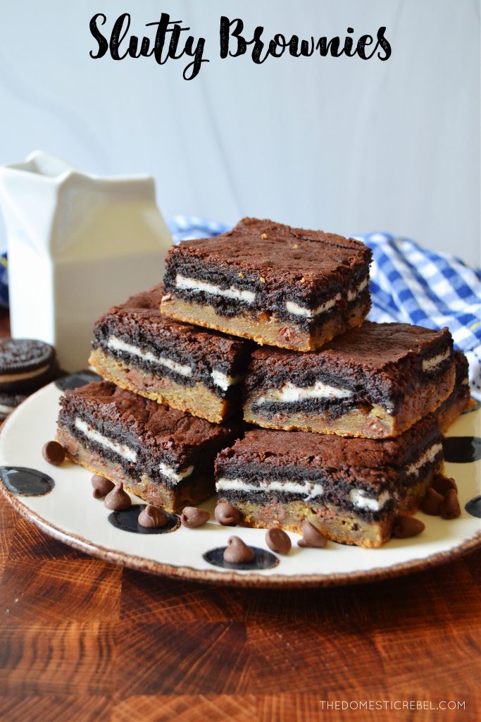 a huge stack of slutty brownies on a black and white dotted plate