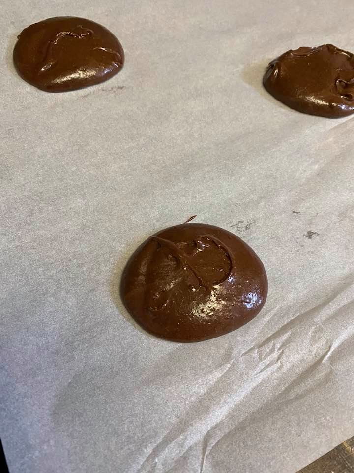 a photo of cosmic brownie cookie dough on a baking sheet before baking