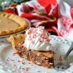 a piece of chocolate peppermint chess pie topped with whipped cream and candy cane pieces on a white plate