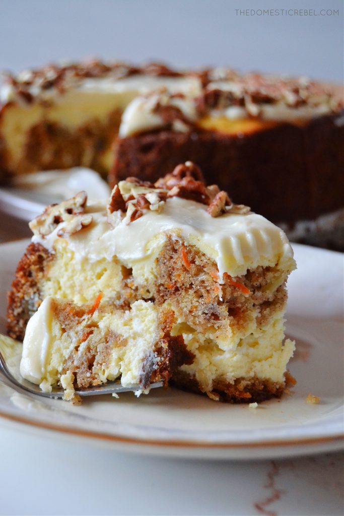 a piece of carrot cake cheesecake with a bite on a fork