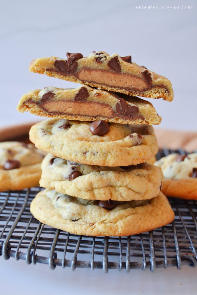 a stack of cookies with a split open peanut butter stuffed cookie on top 