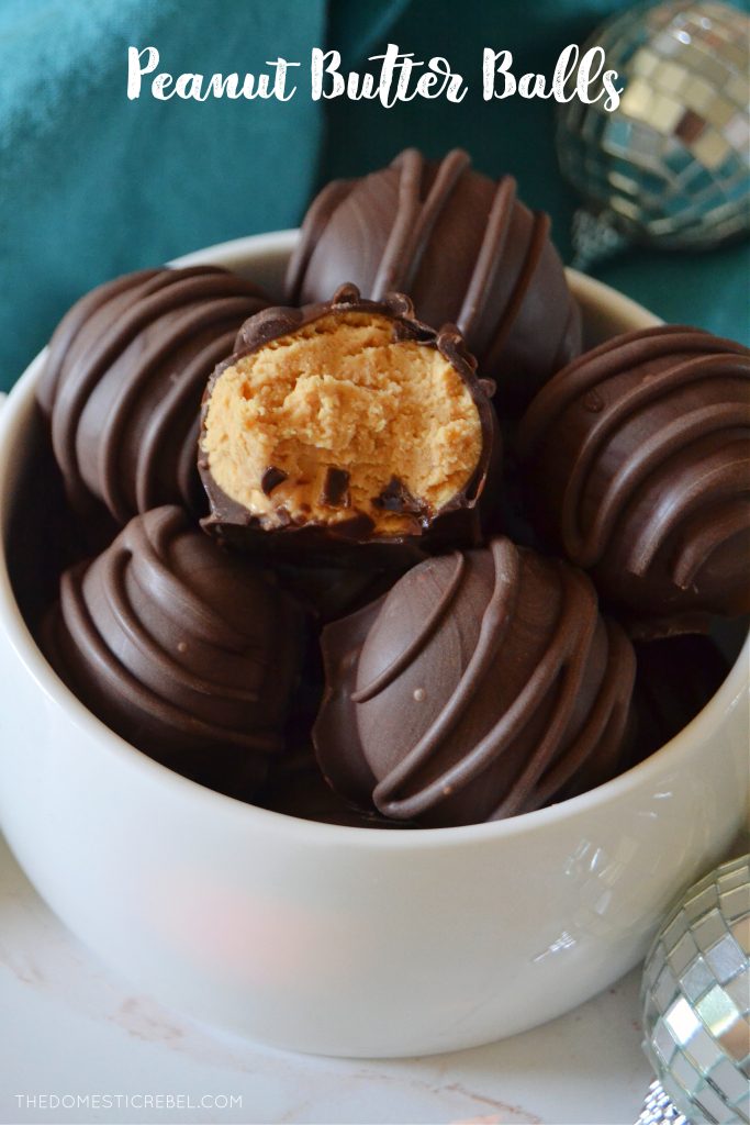 a small white bowl filled with peanut butter truffles and one truffle has a bite missing from it