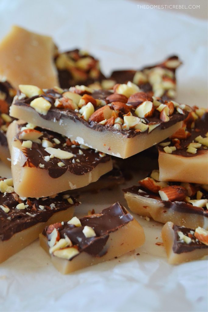 a pile of almond roca toffee on a white piece of parchment paper