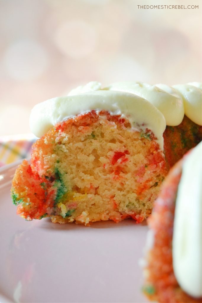 A photo of the Funfetti Bundt cake's side to show the inside of the cake's texture as it rests on a pink cake stand.