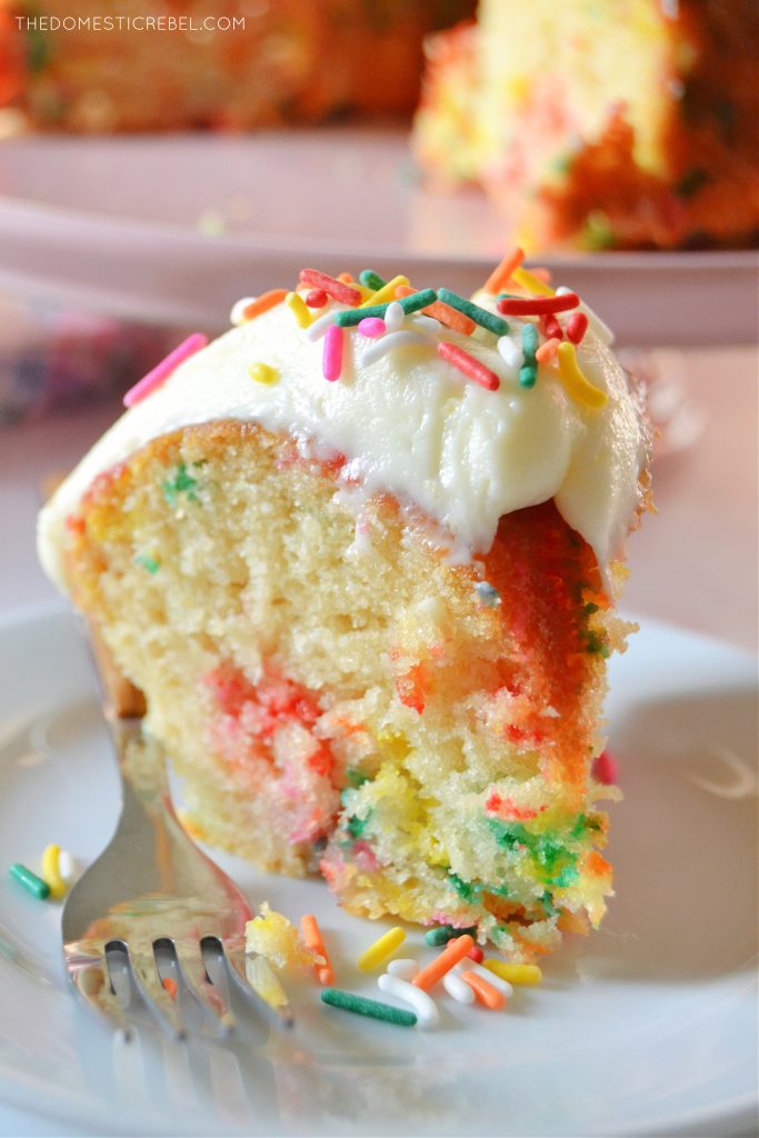 a piece of homemade funfetti bundt cake on a little white plate with a silver fork next to it