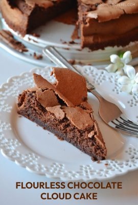 a slice of flourless chocolate cloud cake on a white lacy plate with a fork on the plate.