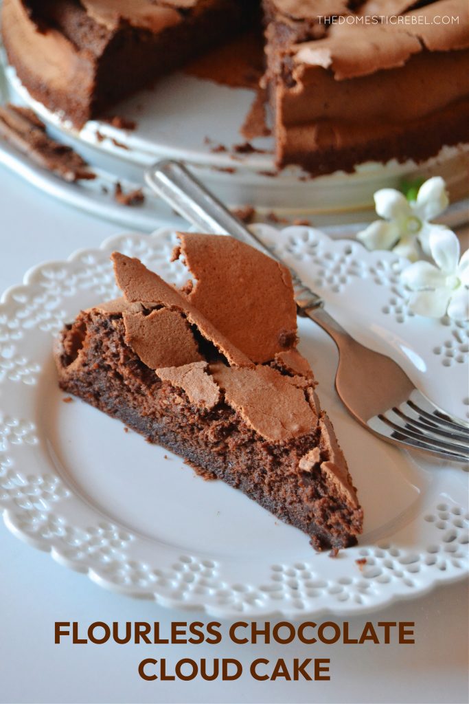 a piece of flourless chocolate cloud cake is on a lacy scalloped plate with a fork resting on the plate.