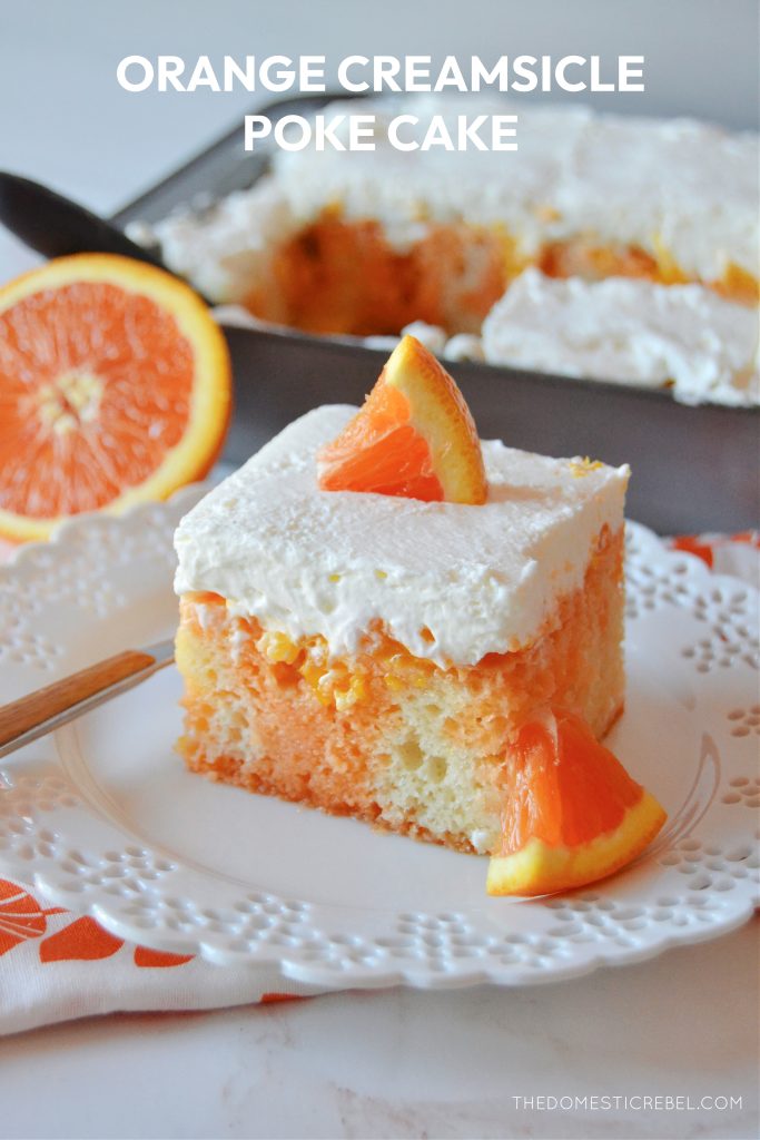 a square piece of orange creamsicle poke cake on a scalloped white plate with a fork. an orange segment and a pan of cake sit in the background. 