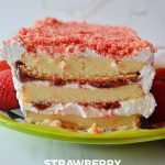 strawberry shortcake icebox cake sits on a green ceramic platter against a white background.