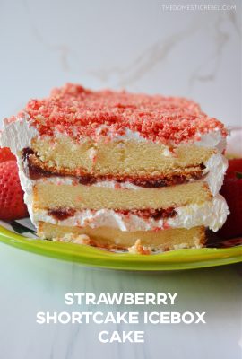 strawberry shortcake icebox cake sits on a green ceramic platter against a white background.