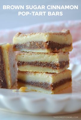 four pop tart bars on a white scalloped plate stacked high.