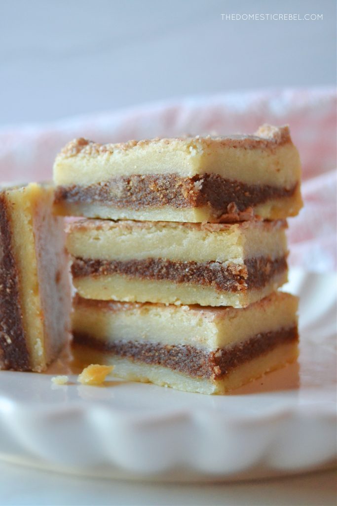 a trio stack of brown sugar cinnamon pop tart bars on a white plate with one bar on its side next to the stack.