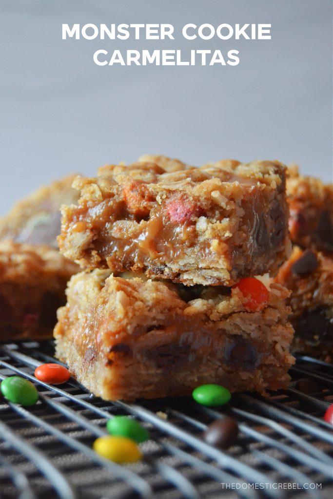 a double stack of monster cookie carmelitas on a black cooling rack with mini M&M candies surrounding them. 