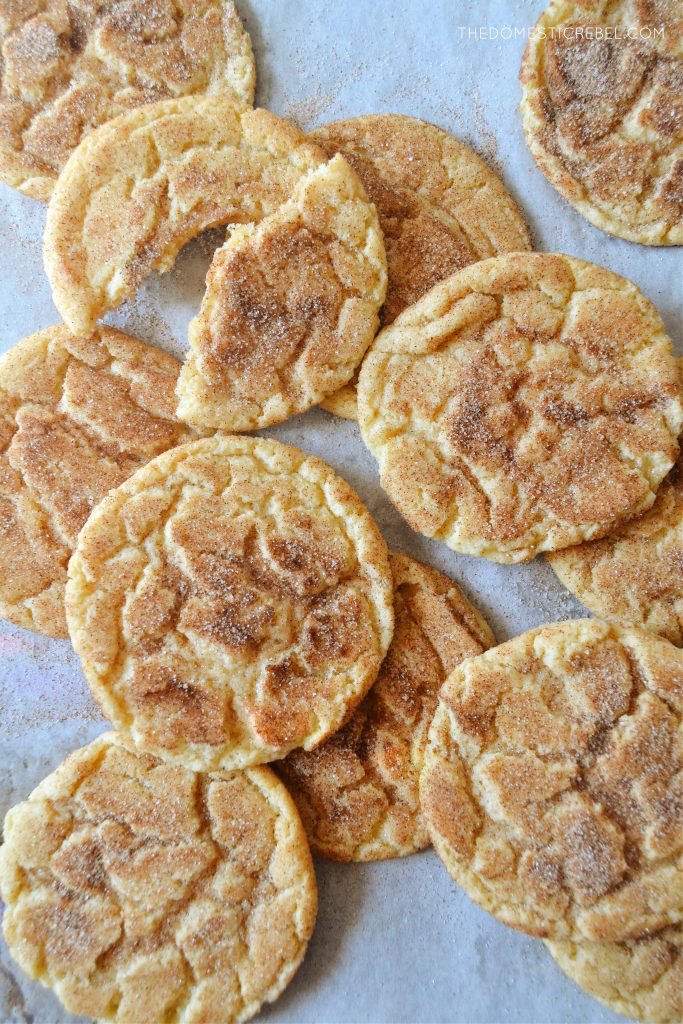 a random arrangement of brown butter snickerdoodle cookies on a parchment-lined baking sheet.