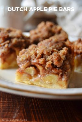 a dutch apple pie bar photographed up close to show texture. it sits on a white plate on top of a wooden cutting board.